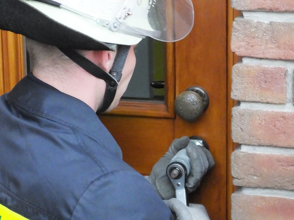 Ein Feuerwehrmann setzt die Türziehglocke an, um die Tür zu Öffnen. Bei diesem Bild handelt es sich um ein Symbolfoto, welches in keinem Zusammenhang mit dem Einsatz steht.